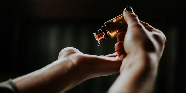 Pouring oil into hand from bottle